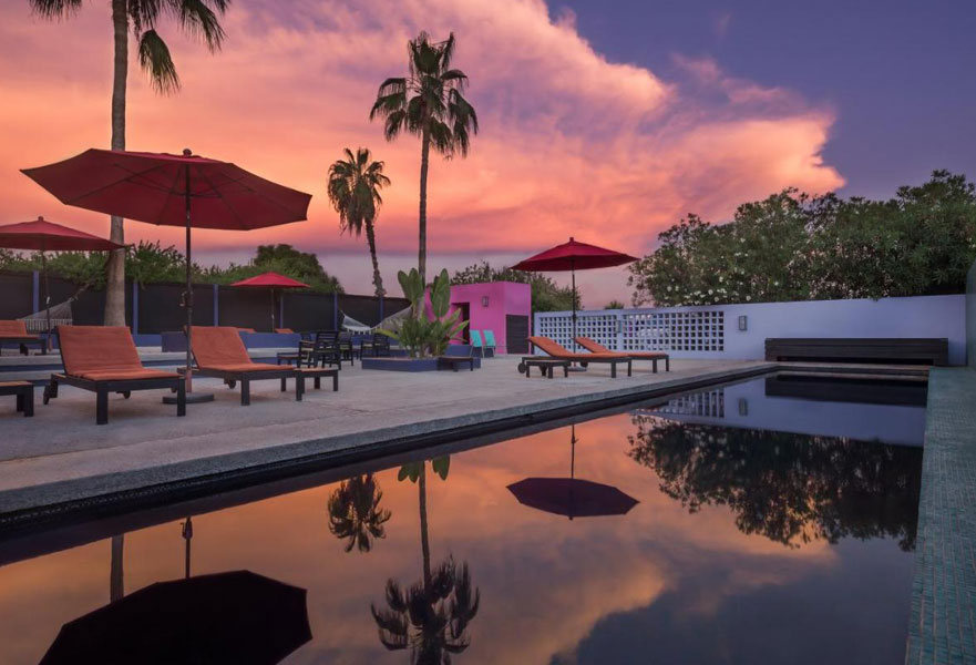 Sunset view near a pool area with shades and 4 sun loungers at The Hotelito Todos Santos in Baja California Sur, Mexico.