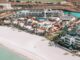 Aerial view of Costa Baja La Paz beach club with white sand and crystal-clear waters.