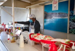 Fish tacos Albatros owner servir tacos to a customer inside his food stand, La Paz, Mexico.