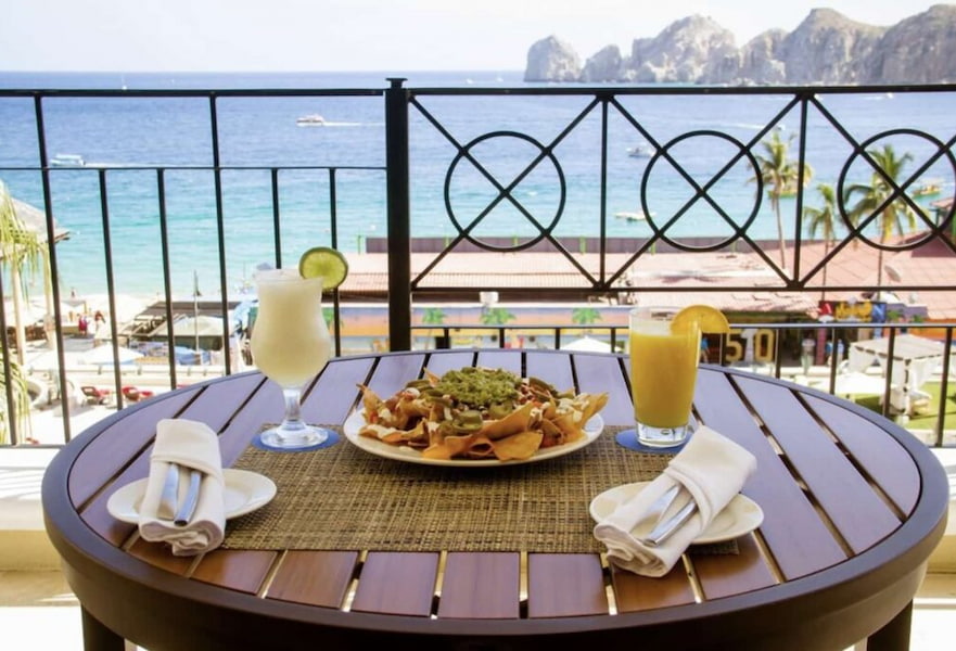 Chilaquiles dish served with two drinks in a table overlooking Medano beach.