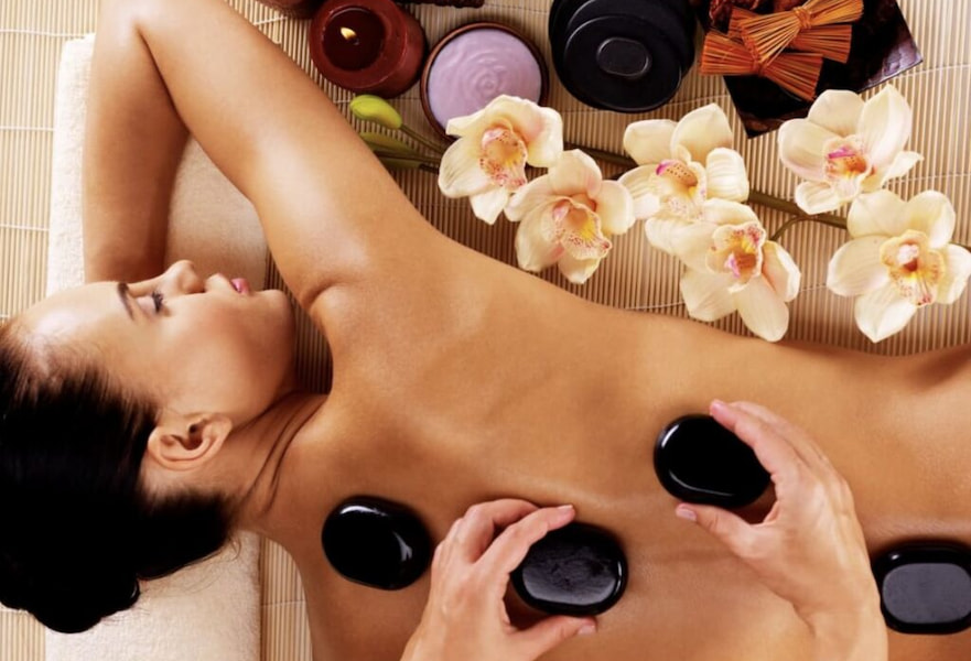 Woman relaxed receiving a hot stone massage at SaltwaterSpa in Casa Dorada Los Cabos, Mexico.
