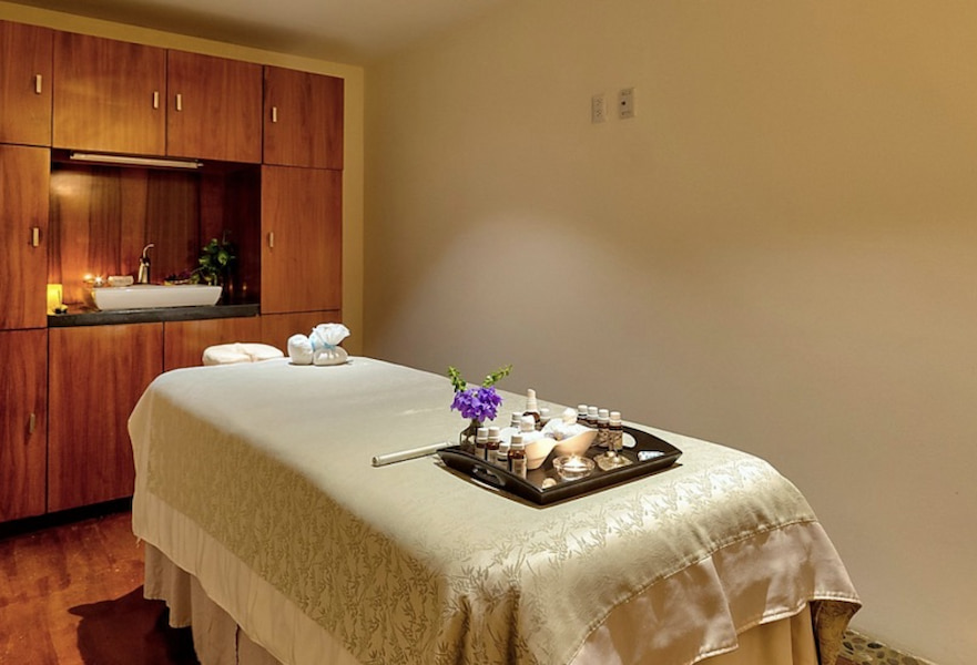 Costa Baja Espíritu Spa interior with a massage bed prepared with body oils and candles.