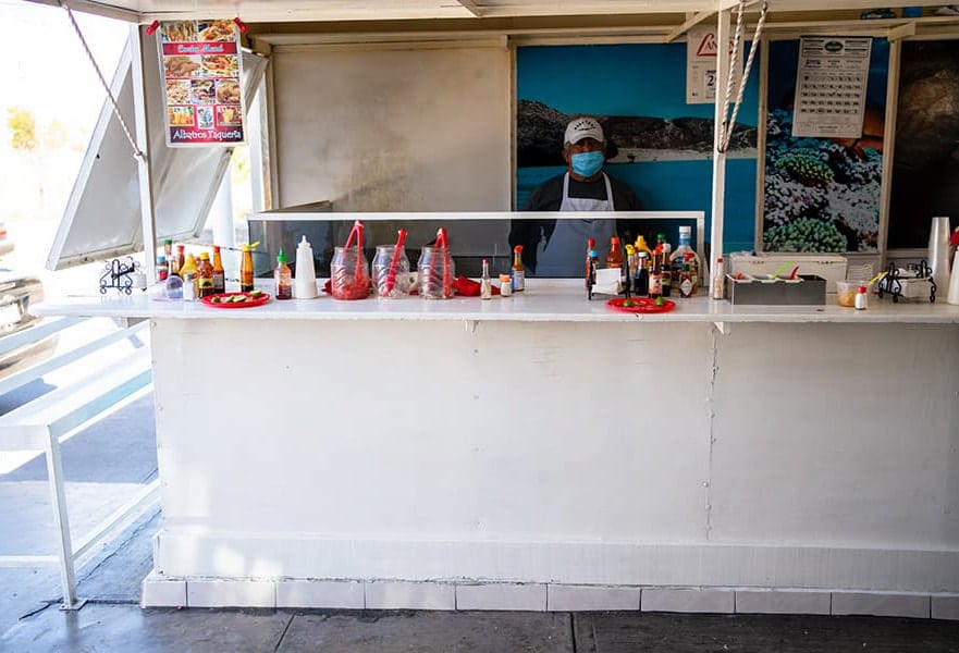 Albatros fish taco stand with owner inside and the sauce bar in front, La Paz, Mexico.