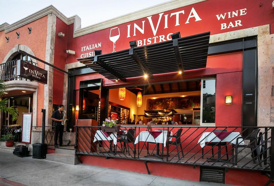 Bright red main entrance of Invita Bistro restaurant in Cabo San Lucas, Mexico.