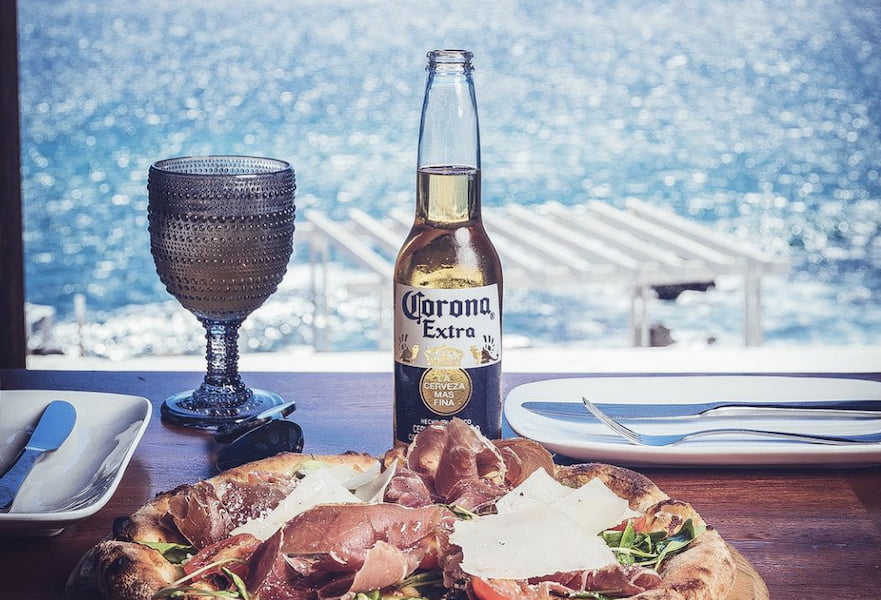 Prosciutto ham pizza served with a corona beer in a ocean view table at Jazz on the Rocks restaurant in Los Cabos, Mexico.