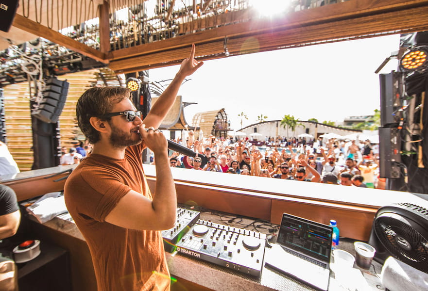 Dj playing at Omnia Dayclub in front of many people having fun and partying in Los Cabos, Mexico.