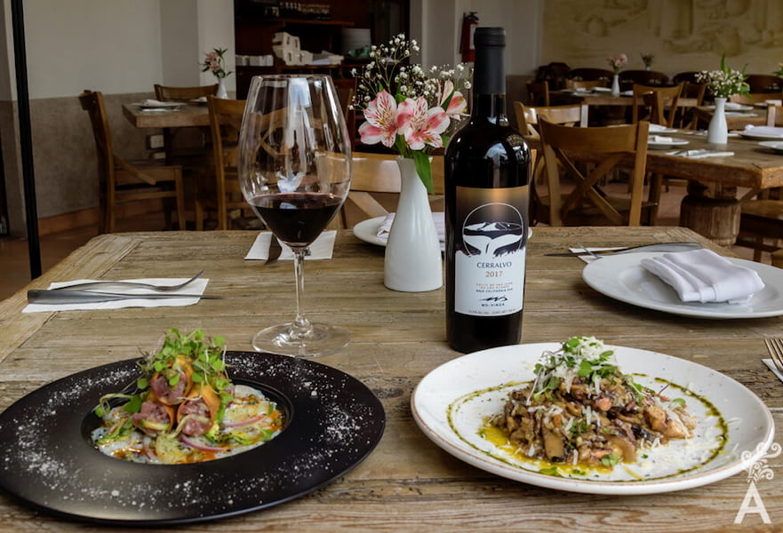 Two dishes served with a glass and bottle of wine at Sorstis restaurant in La Paz, Mexico.
