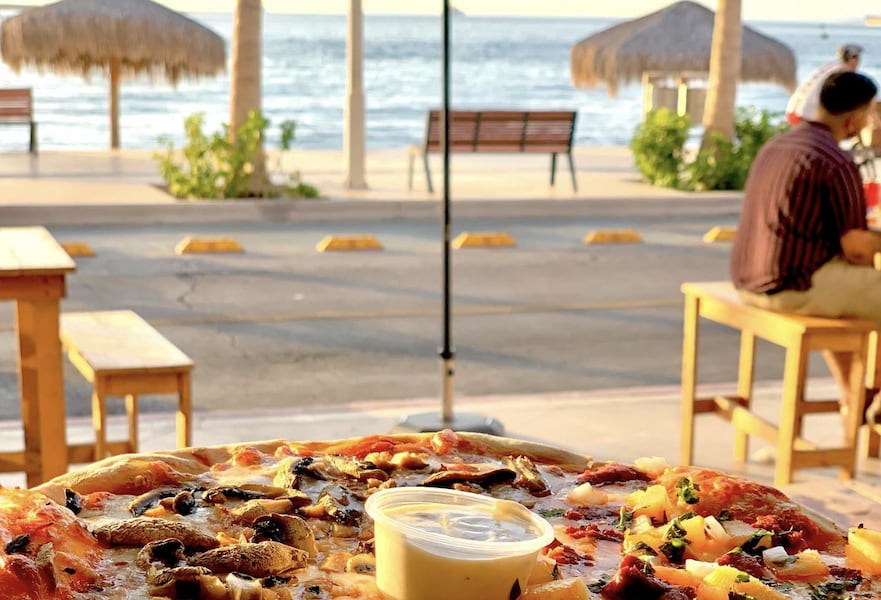 Pizza with creamy dressing served at Baja Bonita restaurant bar with ocean view of La Paz Mexico Malecon.