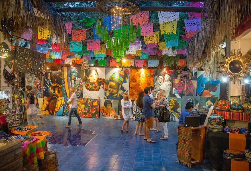 Indoor picture of the Art Distric gallery in San José del Cabo, Mexico. Colorful ceiling Mexican deco and tourist walking around.