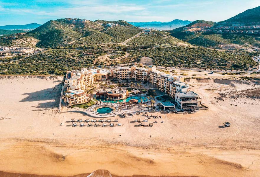 Aerial view of The Towers at Pueblo Bonito Pacifica, green mountains on the back, large pristine beach on the front, Los Cabos, Mexico.