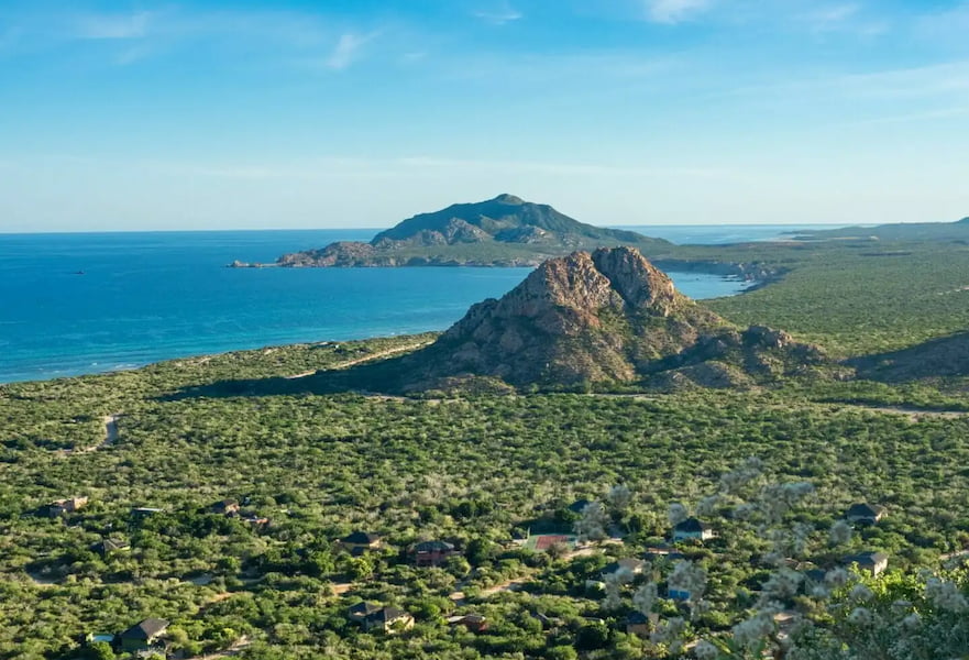 Aerial view of Cabo Pulmo in BCS, Mexico, loads of vegetation and few little buildings near the ocean.