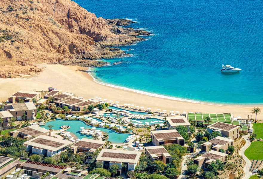 Aerial view of Montage Los Cabos, a luxurious beachfront resort in Mexico, surrounded by crystal-clear turquoise waters