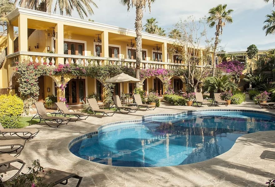 Poolside with green bushes and sun loungers at El Encanto Inn, San José del Cabo, Mexico